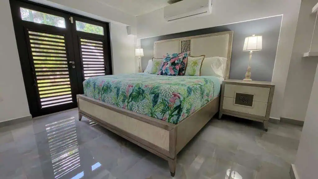 Bright bedroom with tropical-themed bedding and sleek furniture.