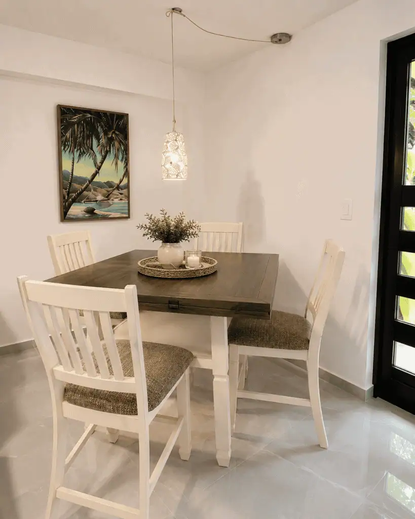 Bright dining room with tropical artwork and white furniture.