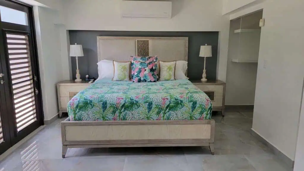 Bright bedroom with tropical-themed bedding and minimalist furniture.