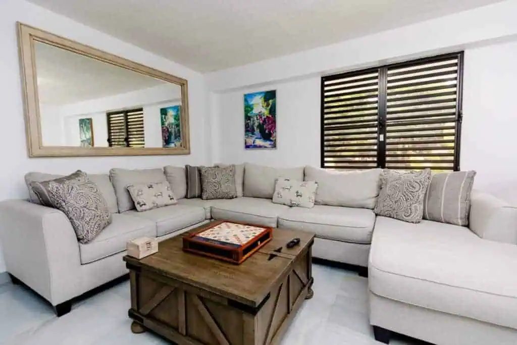 Bright living room with white sectional sofa and wooden coffee table.